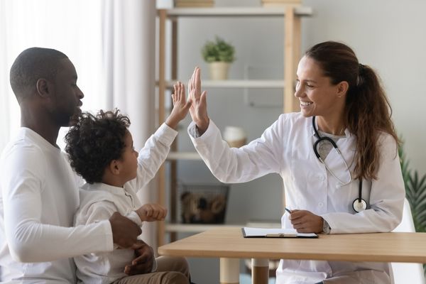 father and son highfiving doctor