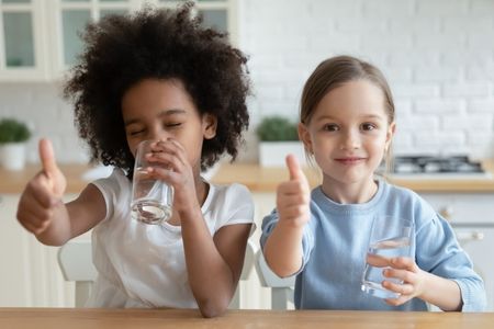 two kids drinking water