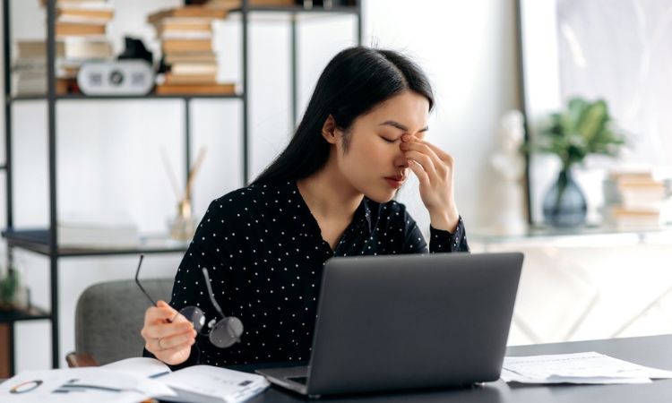 woman hand to head stressed at work