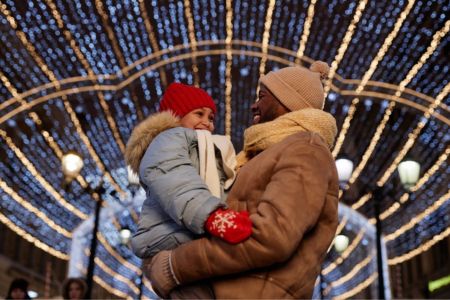 father holding son both all bundled up in winter clothes