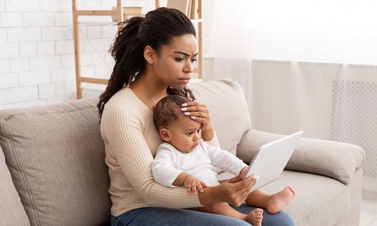 mother holding child while reading