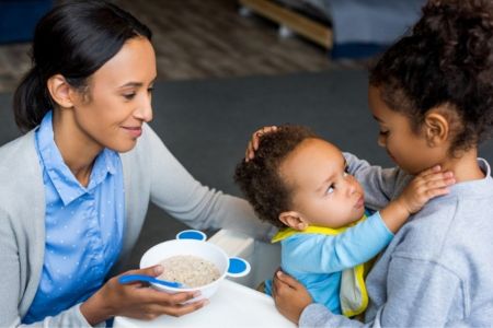 mother feeding her two children