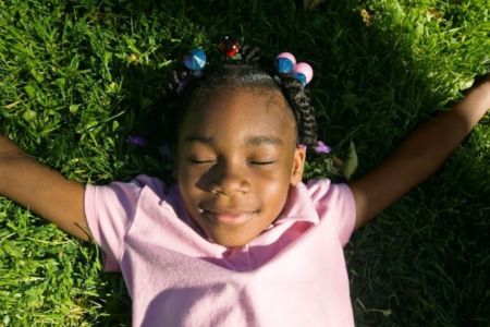 little girl laying out in the grass