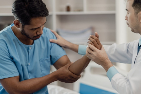 patient being examined for a sore arm by a doctor