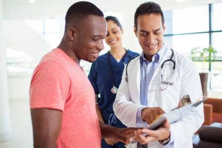 patient with doctor and nurse going over good news
