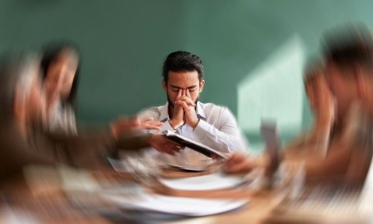 man stressed out at work with the picture purposely out of focus