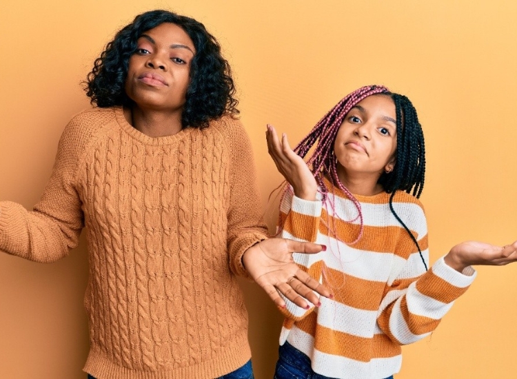 mother daughter side by side with arms in the air suggesting "who knows"